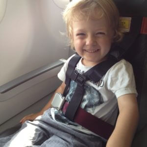 Mit Cares-Gurt im Flugzeug gesichertes Kleinkind