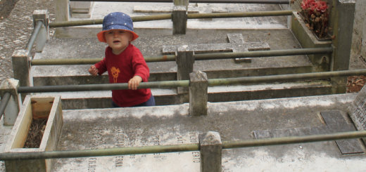 Kleines Kind zwischen Gräbern auf einem Friedhof